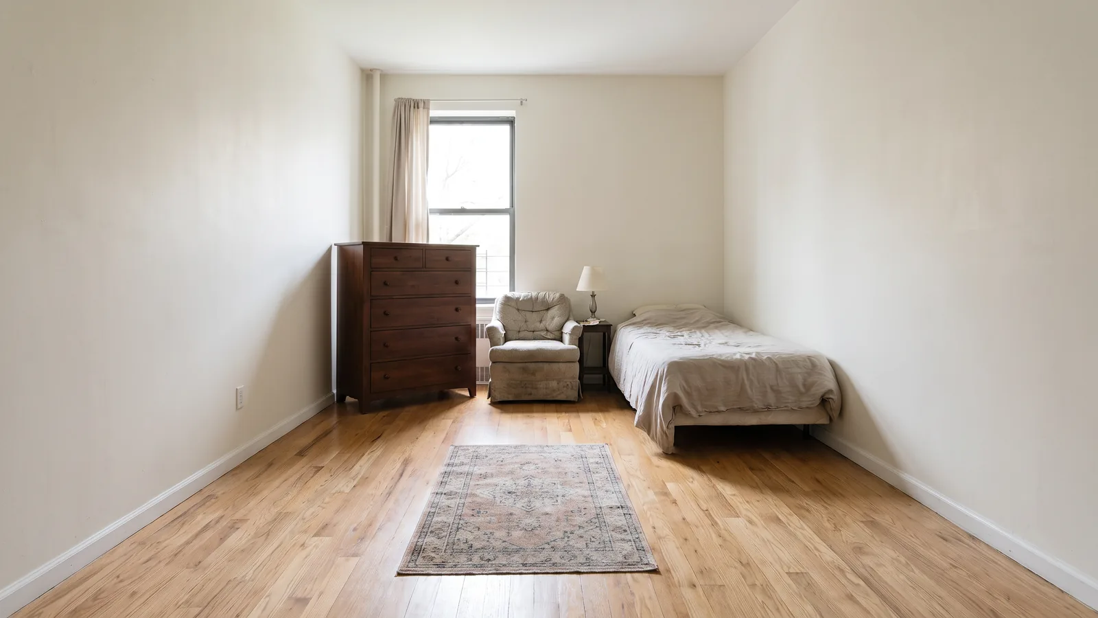 Un studio avec tous les meubles poussés contre les murs et un centre vide